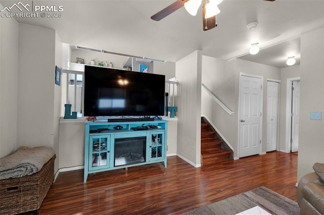 living room with ceiling fan and dark wood-type flooring