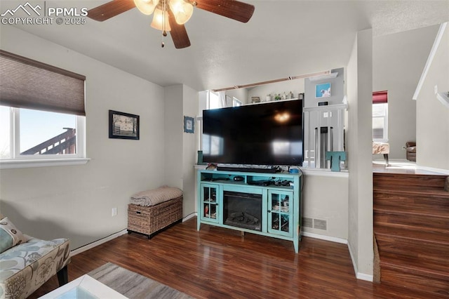 living room with dark hardwood / wood-style flooring and ceiling fan