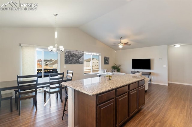 kitchen with dark hardwood / wood-style floors, a kitchen island, pendant lighting, and ceiling fan with notable chandelier