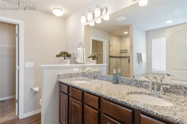 bathroom featuring wood-type flooring, vanity, toilet, and a shower with shower door