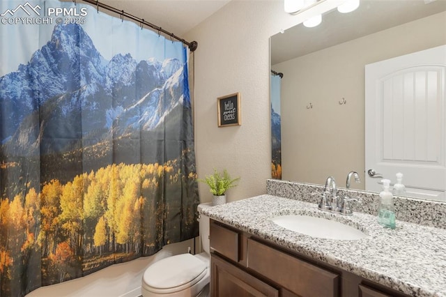 bathroom with a shower with shower curtain, vanity, and toilet