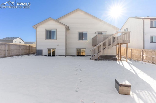 snow covered back of property with central AC unit