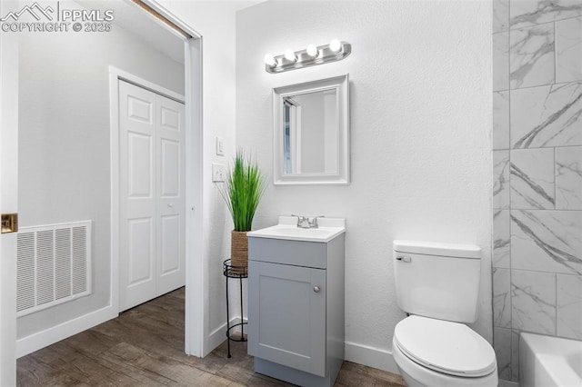 bathroom featuring wood-type flooring, toilet, and vanity