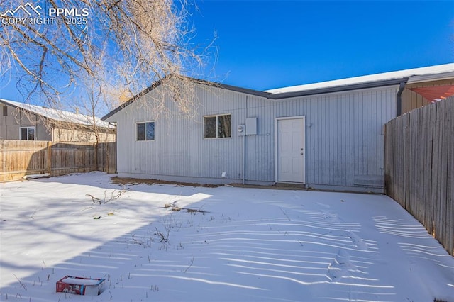 view of snow covered back of property