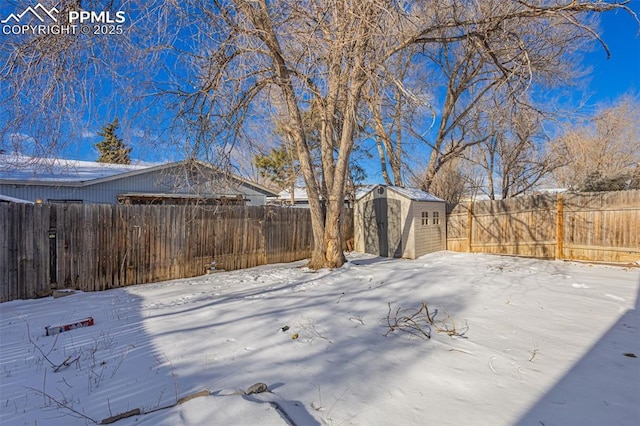 yard covered in snow with a storage shed