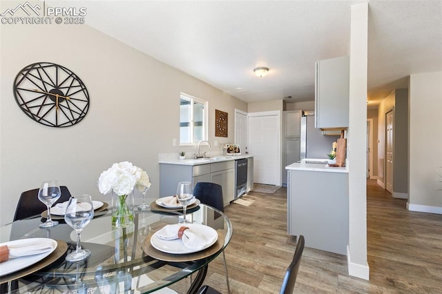 dining room featuring sink and light hardwood / wood-style floors