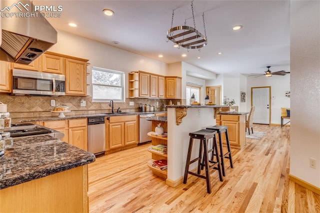 kitchen featuring light brown cabinetry, island range hood, a center island, and stainless steel appliances