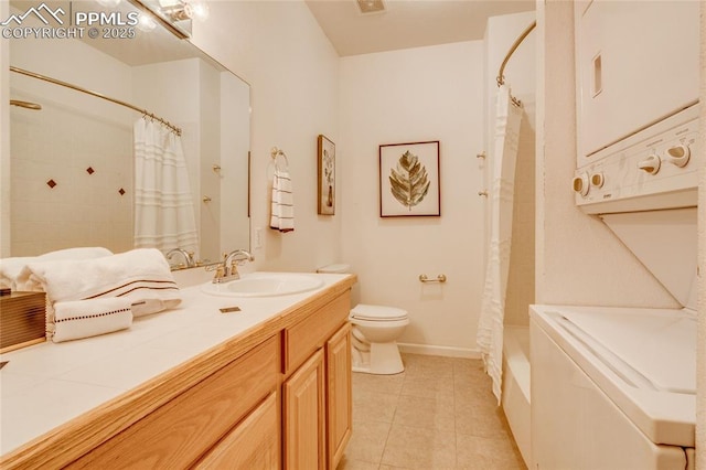 bathroom featuring toilet, stacked washer / dryer, tile patterned floors, and vanity