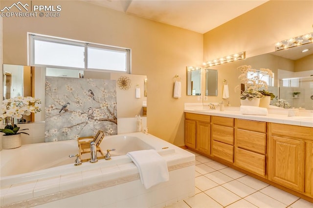 bathroom featuring vanity, tile patterned flooring, and tiled tub