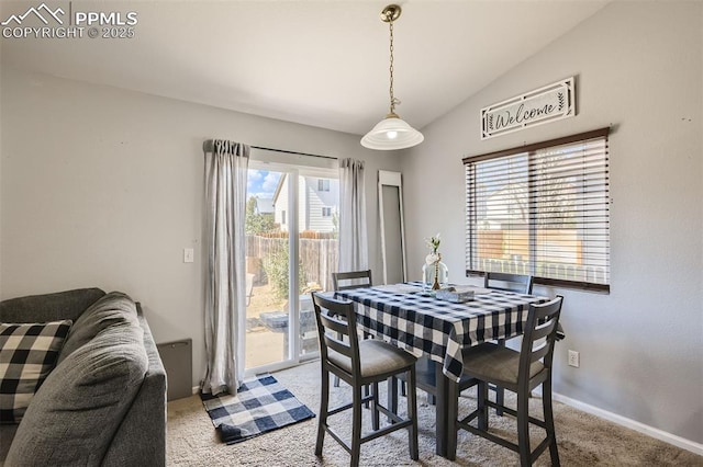 dining area with light carpet and lofted ceiling