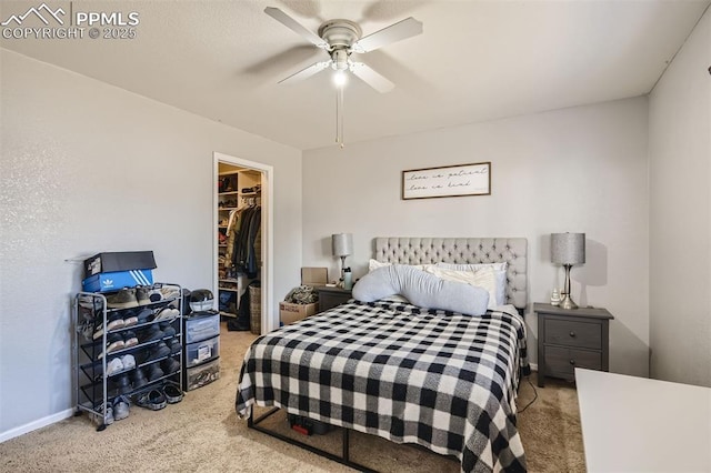 bedroom with light carpet, a closet, ceiling fan, and a walk in closet