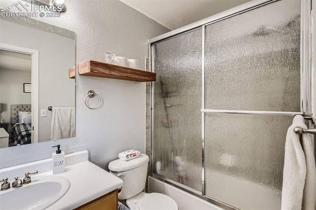 full bathroom featuring vanity, shower / bath combination with glass door, a textured ceiling, and toilet