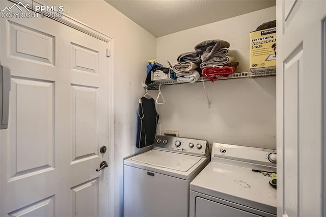 laundry area featuring a textured ceiling and washer and dryer