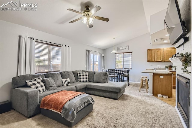 living room featuring vaulted ceiling, ceiling fan, and light carpet