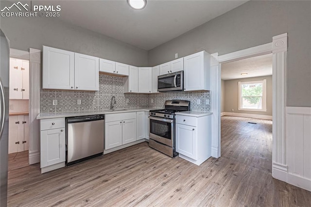 kitchen featuring white cabinets, light hardwood / wood-style floors, sink, and stainless steel appliances