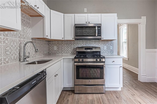 kitchen featuring white cabinets, decorative backsplash, sink, and stainless steel appliances