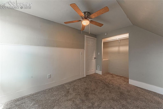 unfurnished bedroom featuring ceiling fan, a closet, carpet floors, and lofted ceiling