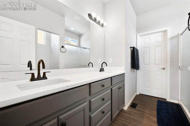 bathroom with a shower with door, vanity, and wood-type flooring