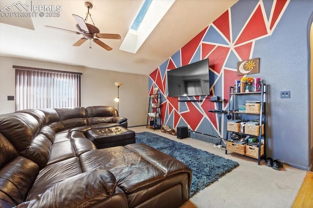 living room featuring ceiling fan and vaulted ceiling with skylight