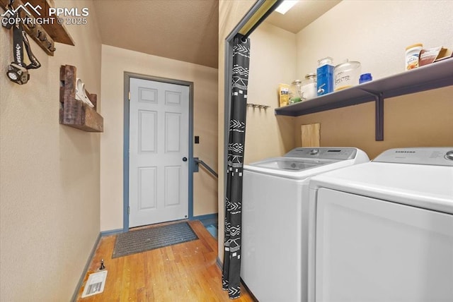 laundry room featuring light wood-type flooring and washing machine and clothes dryer