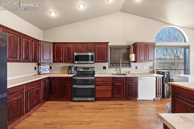 kitchen featuring sink, high vaulted ceiling, stainless steel appliances, and light wood-type flooring