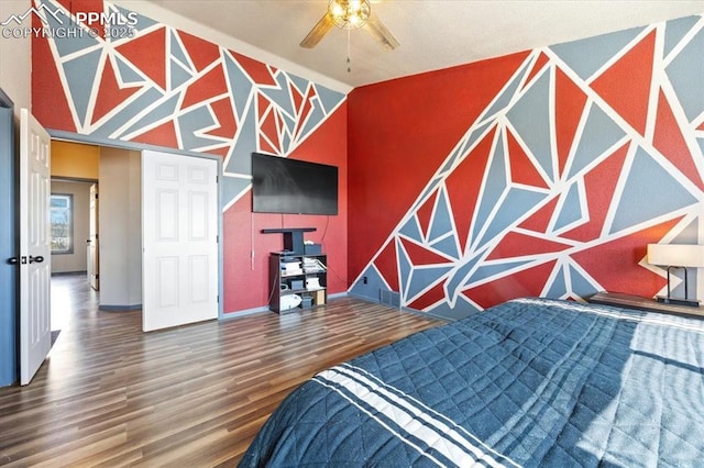 bedroom with ceiling fan, lofted ceiling, and hardwood / wood-style flooring