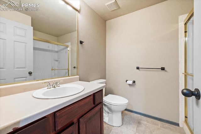 bathroom with vanity, toilet, and a shower with door