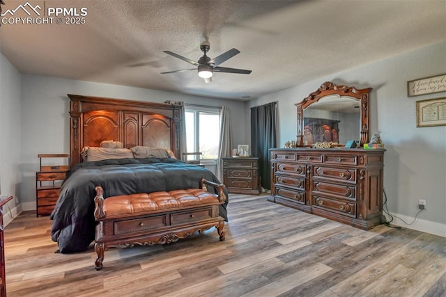 bedroom with a textured ceiling, light hardwood / wood-style flooring, and ceiling fan