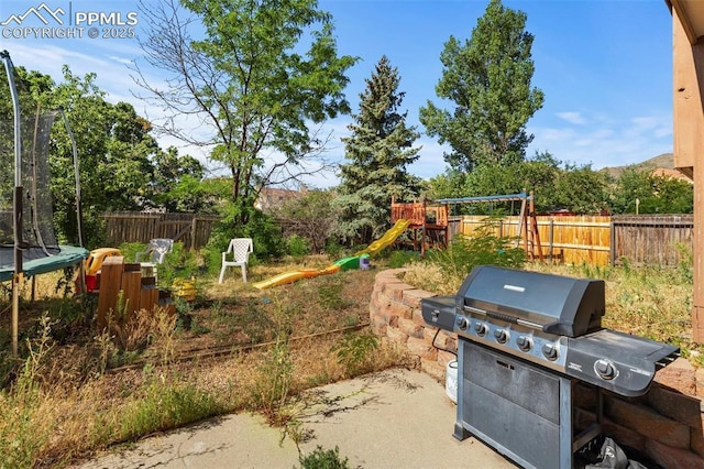 view of patio / terrace with a playground, a grill, and a trampoline