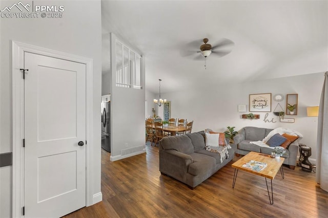 living room featuring dark hardwood / wood-style flooring and ceiling fan with notable chandelier