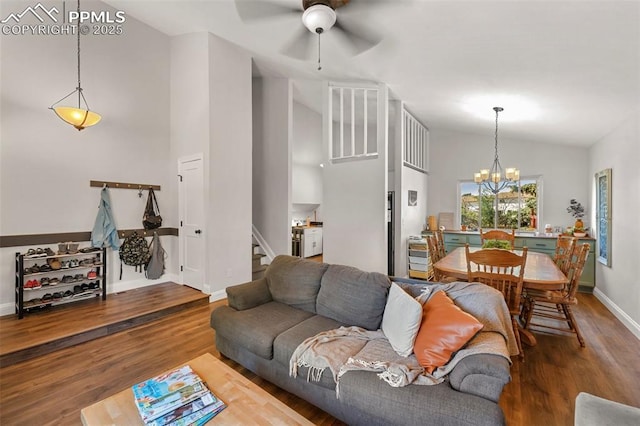 living room featuring hardwood / wood-style floors, ceiling fan with notable chandelier, and high vaulted ceiling