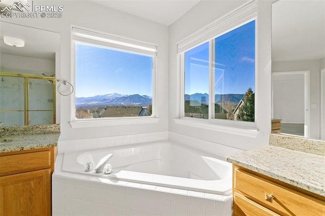 bathroom with shower with separate bathtub, vanity, a wealth of natural light, and a mountain view