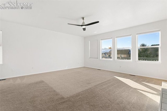 carpeted spare room with ceiling fan