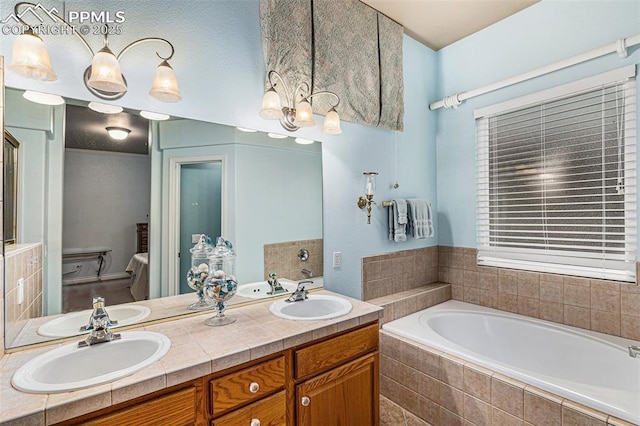 bathroom with vanity and tiled tub