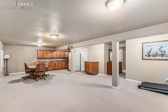 unfurnished dining area featuring a textured ceiling and light carpet