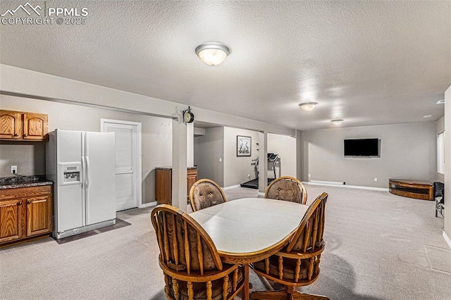 carpeted dining space with a textured ceiling