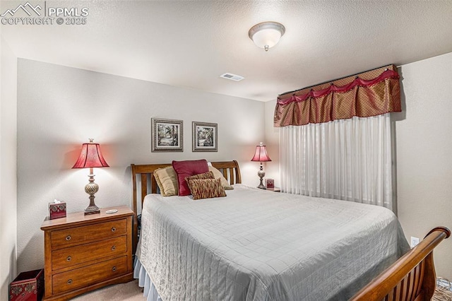 carpeted bedroom featuring a textured ceiling