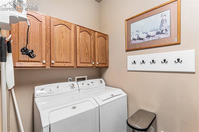 clothes washing area with washer and clothes dryer and cabinets