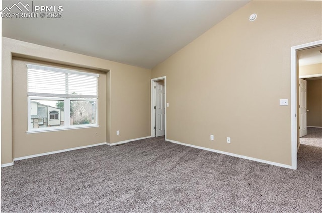 carpeted empty room with vaulted ceiling