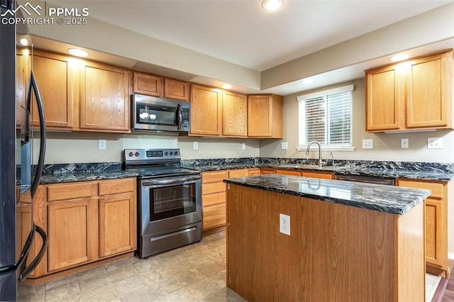 kitchen featuring a kitchen island, sink, stainless steel appliances, and dark stone counters