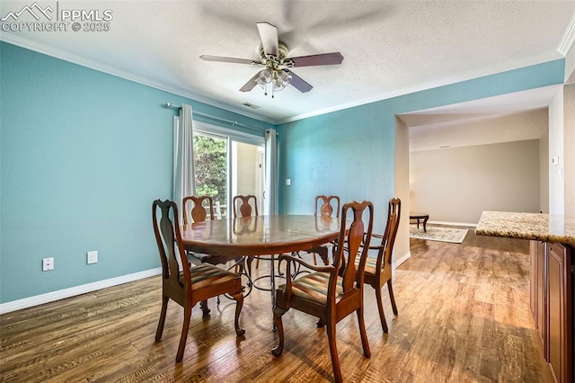 dining room with crown molding, ceiling fan, and dark wood-type flooring