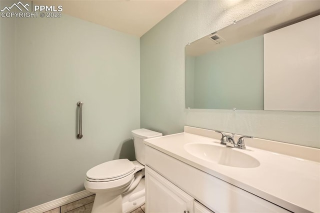 bathroom with tile patterned flooring, vanity, and toilet