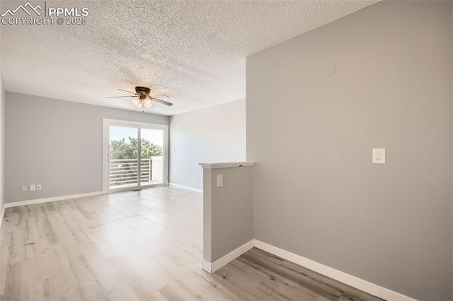 unfurnished room featuring ceiling fan, light wood-type flooring, and a textured ceiling