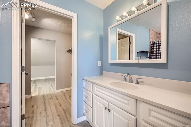 bathroom featuring vanity, a shower with curtain, a textured ceiling, and hardwood / wood-style flooring