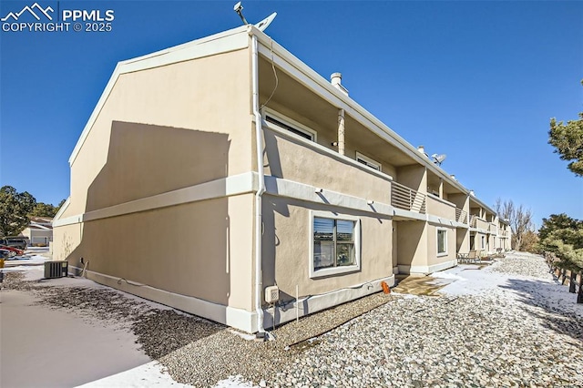 view of side of home featuring a balcony and central AC