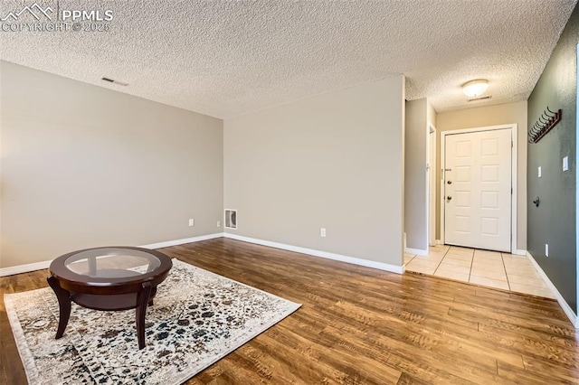 sitting room with wood-type flooring and a textured ceiling