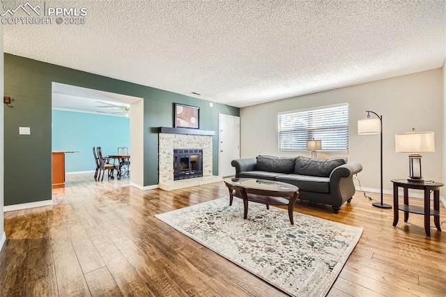 living room with ceiling fan, hardwood / wood-style floors, and a textured ceiling