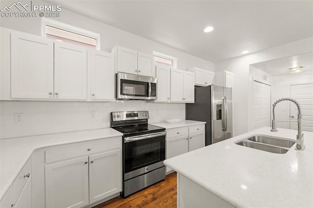 kitchen with white cabinetry, sink, dark hardwood / wood-style flooring, decorative backsplash, and appliances with stainless steel finishes