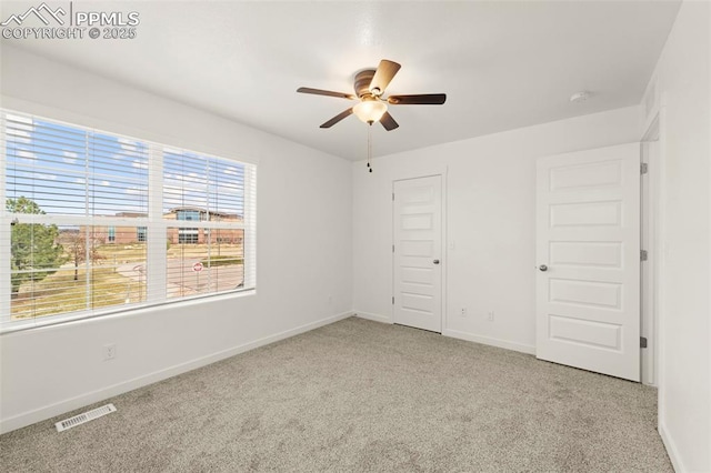 unfurnished bedroom featuring light carpet, a closet, and ceiling fan