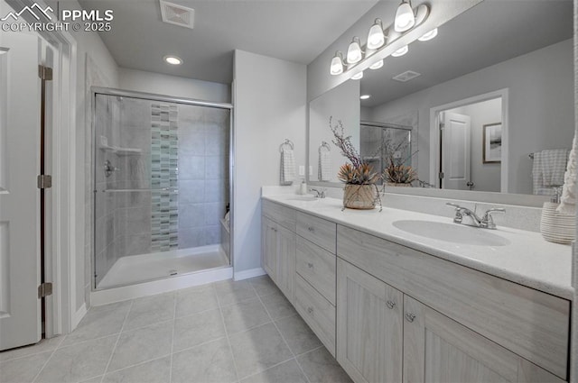 bathroom featuring tile patterned flooring, vanity, and walk in shower